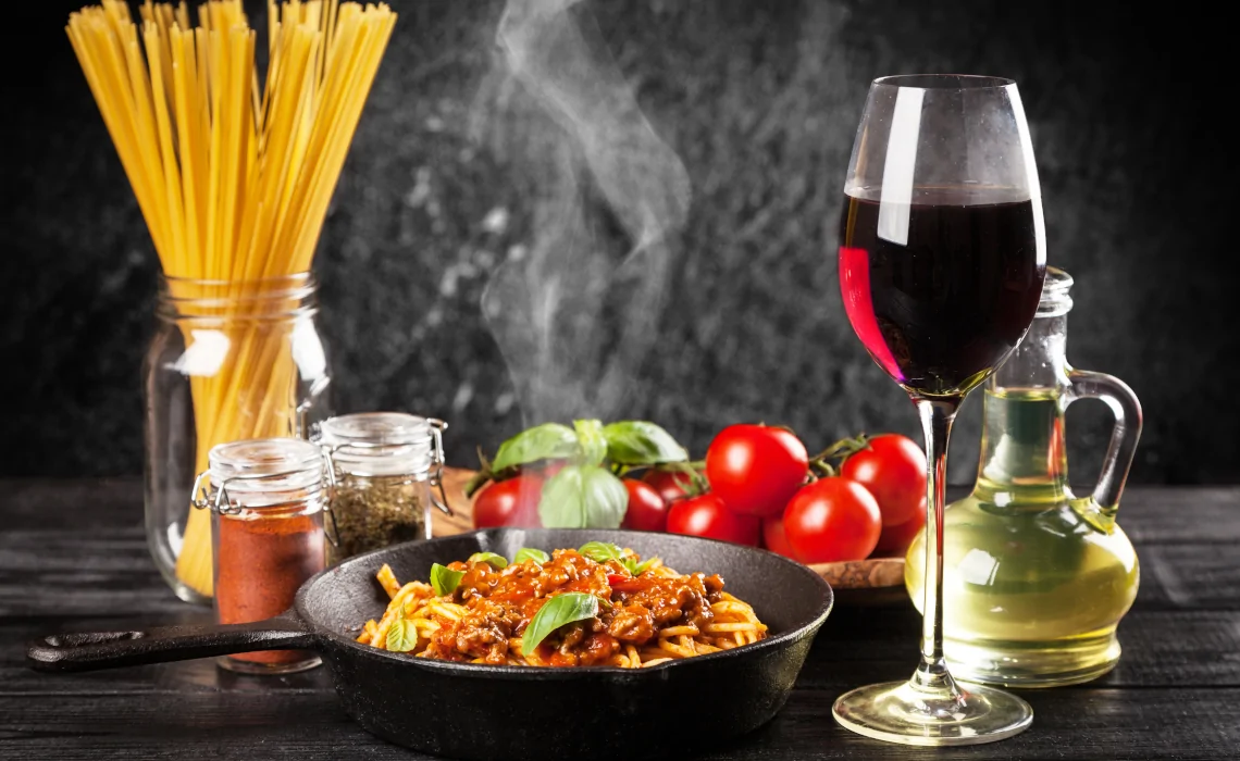 Smoking Pasta with meat sauce, spices, tomatoes, olive oil and glass of red wine