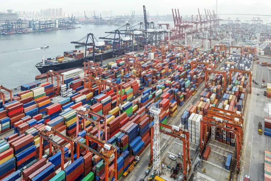 Pile of sea freight containers loading on the ship in a busy container port