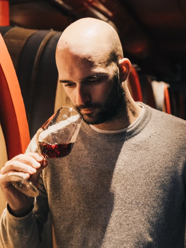 Nicola Scienza, owner of Rubinelli Vajol, holding a glass of wine, in the undergroung cellar, Valpolicella, Italy