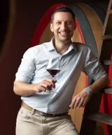 Paolo Demarie holding a glass of Barolo in his hand, in Demarie winery in Vezza d'Alba, Piemonte, Italy