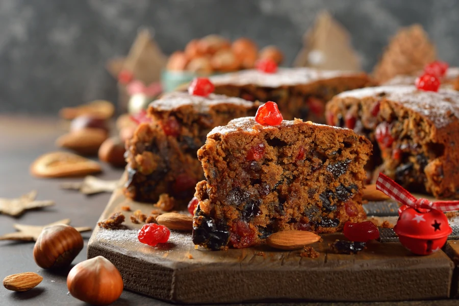 Slices of Christmas cake on the board and nuts