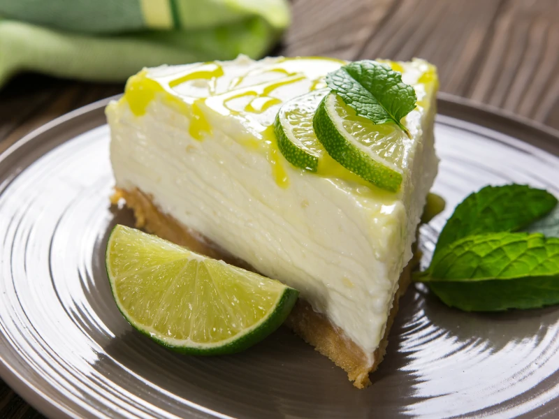 Cheesecake with lime, mascarpone cheese and mint on a plate