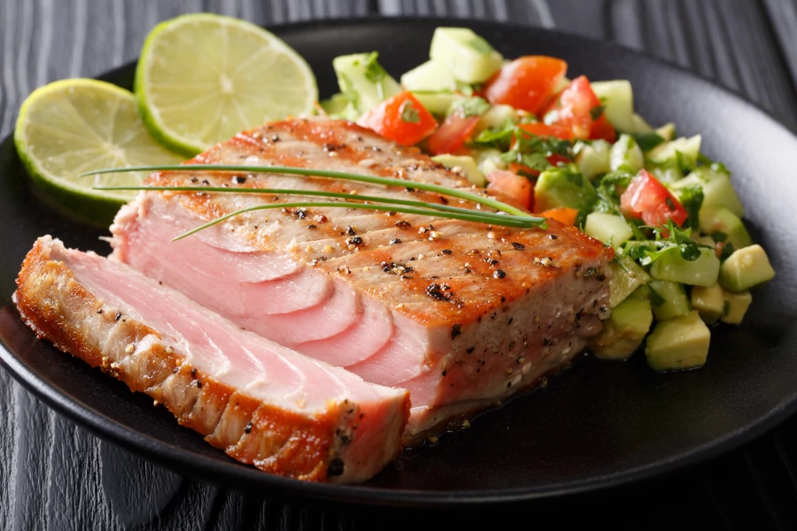 Barbecue tuna steak with lime and avocado cucumber salsa