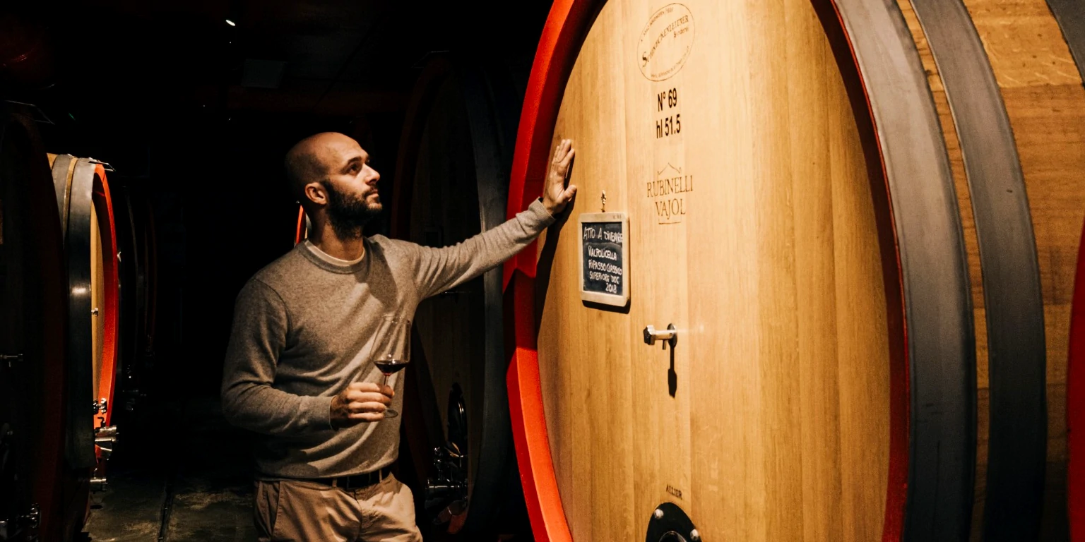 Nicola Scienza, holding a glass of Amarone wine, in the undergroung ageing cellar, Rubinelli Vajol, Valpolicella, Italy