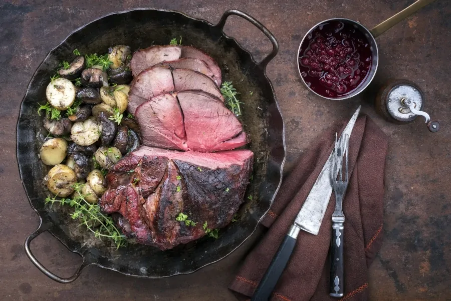 Roasted venison with mushrooms and potatoes and cranberry sauce