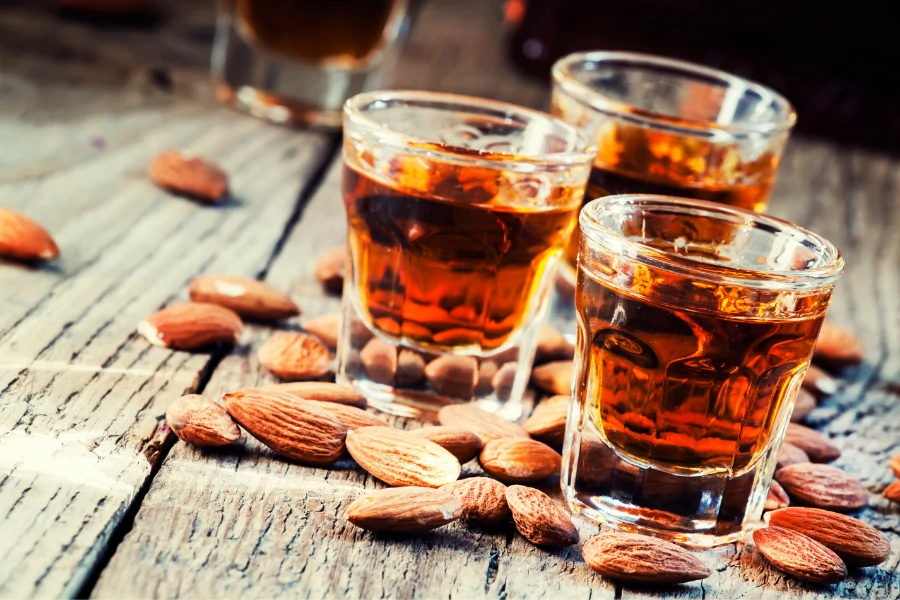 Three Glasses of Amaretto Liqueur and Almonds on a table