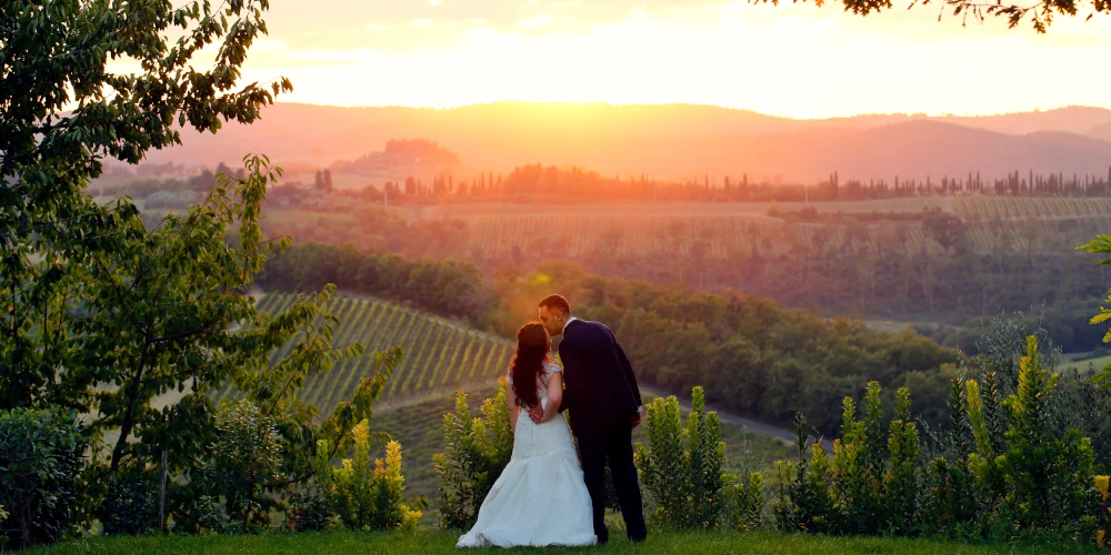 Wedding in Italy, couple kissing in front of Italian vineyards