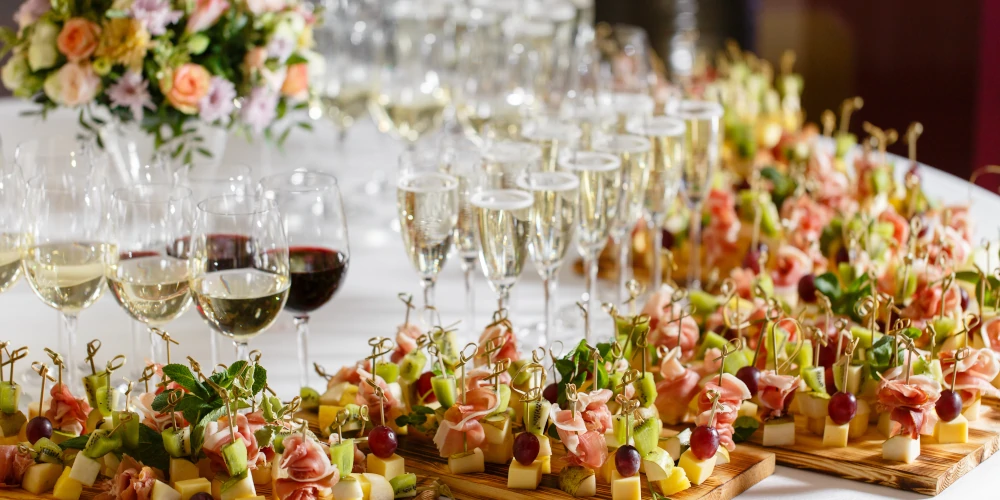 Wedding party table, canape food and glasses of red, white and sparkling wine